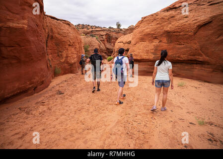 Visiteurs marche dans le Canyon Waterhole - un emplacement canyon coupant à travers les rochers de grès Navajo rouge près de Page, Arizona, USA Banque D'Images