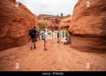 Visiteurs marche dans le Canyon Waterhole - un emplacement canyon coupant à travers les rochers de grès Navajo rouge près de Page, Arizona, USA Banque D'Images