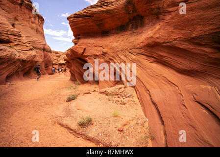 Visiteurs marche dans le Canyon Waterhole - un emplacement canyon coupant à travers les rochers de grès Navajo rouge près de Page, Arizona, USA Banque D'Images