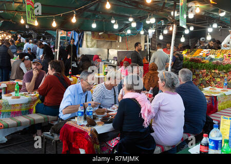 Marrakech tourisme - les touristes de manger le soir à un blocage de l'alimentation en place Djemaa el Fna, Marrakech Medina, Maroc Sud Banque D'Images