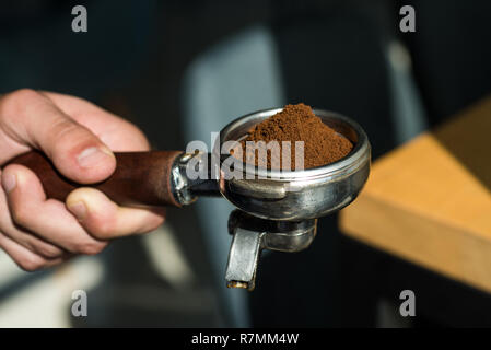 Laissez notre passion soit votre plaisir. Le café de l'équipement. Tenir en main portafilter Barista. Brews Barista espresso coffee dans le café. Café au café Café frais moulu Banque D'Images