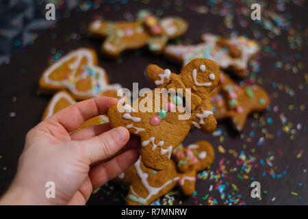 Boulangerie de Noël. Les amis de décorer des biscuits au gingembre avec du glaçage et de la confiserie mastic, vue de dessus. Repas de fête, la famille culi Banque D'Images