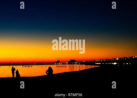 Les gens se rassemblent pour prendre des photos alors que le soleil se couche sur les casinos sur plage de Biloxi de Biloxi, Mississippi, le 24 novembre 2012. Banque D'Images