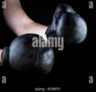 Les mains des hommes portent des gants de boxe noir en cuir ancien, Close up Banque D'Images