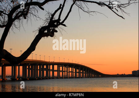 Le soleil se couche sur le pont de la baie de Biloxi, vu de l'avant plage à Ocean Springs, Mississippi, le 18 décembre 2010. Banque D'Images