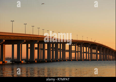 Le soleil se couche sur le pont de la baie de Biloxi, vu de l'avant plage à Ocean Springs, Mississippi, le 18 décembre 2010. Banque D'Images