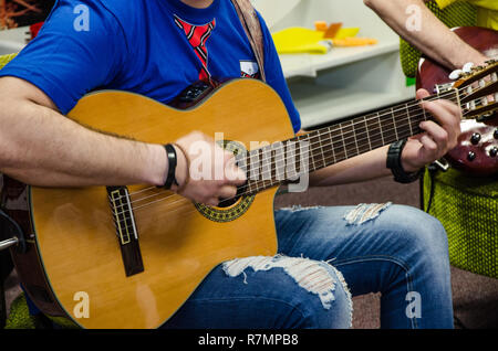 Close Up of Man Playing Guitar acoustique amplifiée Banque D'Images