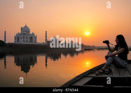 Femme regardant le coucher du soleil sur le Taj Mahal à partir d'un bateau, Agra, Inde. Il a été construit en 1632 par l'empereur Shah Jahan à la mémoire de sa seconde épouse Mumtaz Mah Banque D'Images