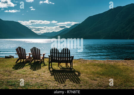 Chaise en bois vides le long des rives du lac Crescent sur la fin de l'après-midi par une journée ensoleillée de début de l'été, la péninsule Olympique, WA, USA Banque D'Images