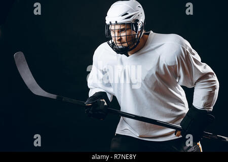 Image de joueur de hockey sur glace en bâton de hockey holding sportswear blanc Banque D'Images