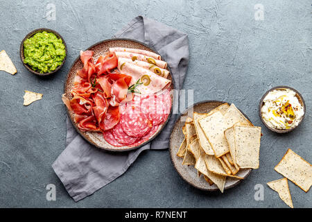 L'antipasto. Plateau de viande, frites et sauces, le vin rouge sur fond gris. Vue d'en haut Banque D'Images