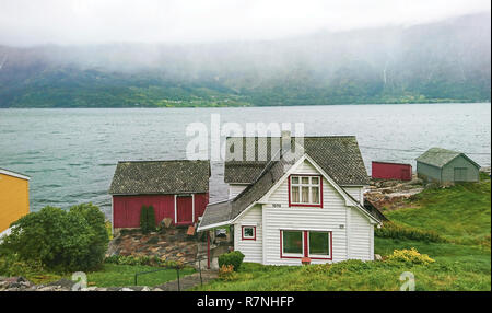 Odda, Norvège - 29 septembre 2018 : Fragment d'un village de pêcheurs sur les rives d'un fjord magnifique dans un matin brumeux, la Norvège. Banque D'Images