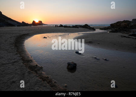 Rivière qui coule vers la mer sur plage à marée basse au coucher du soleil, Zambujeira do Mar, de l'Alentejo, Portugal, Europe Banque D'Images