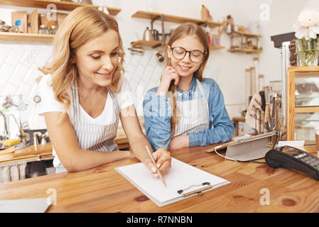 Famille heureuse de prendre des notes tout en travaillant dans un café Banque D'Images