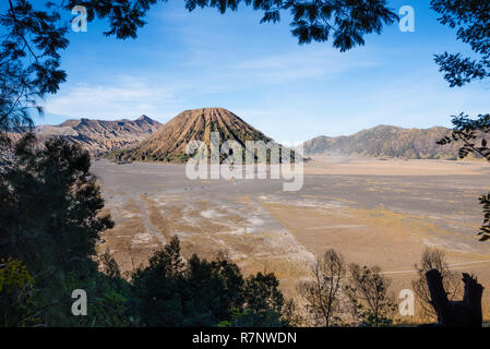 Le Mont Bromo cratère de volcan en éruption dans la caldeira, derrière Gunung Batok, avec Gunung Semeru en arrière-plan, l'île de Java en Indonésie. Banque D'Images