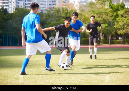 Un groupe de jeunes joueurs de football football asiatique jouant sur la cour extérieure. Banque D'Images