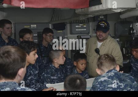 PEARL HARBOR (25 mars 2017) - troisième officier Michael White, officier de quart affecté à l'appel d'offres sous-marin USS Frank Câble (comme 40), montre des graphiques pour les Cadets de la Division de Battleship Texas Hawaii sur la passerelle du navire, le 25 mars. Frank, en route vers Portland, Oregon en cale sèche pour sa disponibilité, l'entretien de la phase d'entretien et de soutien des sous-marins et navires de surface déployée à l'Indo-Asia-région du Pacifique. Banque D'Images