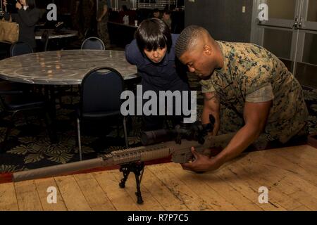 Le Corps des Marines des États-Unis. Ryan Ashe, un breacher avec l'équipe de réaction spéciale (SRT) pour Marine Corps Air Station (MCAS Iwakuni), montre une arme à un membre du siège de la Police de la préfecture d'Hiroshima lors des exercices de formation croisée à MCAS Iwakuni, Japon, le 28 mars 2017. Membres l'Hiroshima et le quartier général de la Police de la préfecture de Yamaguchi s'est rendu à la station aérienne d'observer la conduite de la TRR des scénarios de formation à haut risque. La formation variait de prix-compensation, de violer, de la communication et non létales techniques de retrait. Banque D'Images