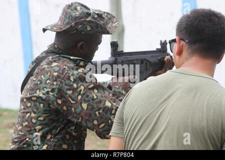 Un U.S. Marine affectés à des fins Maritime Aérien Au sol - Groupe de travail sur la réponse aux crises - l'Afrique fournit des conseils à un membre de l'Ghana Services d'immigration pendant une période d'instruction de maniement des armes en Kpetoe, Ghana, le 22 mars 2017. La formation est une partie d'une évolution de 4 semaines axé sur les patrouilles et le développement cadre avec l'accent sur l'application pratique. Pendant trois années consécutives, SPMAGTF-CR-AF a mené des missions de coopération en matière de sécurité dans le théâtre avec la République du Ghana. Banque D'Images