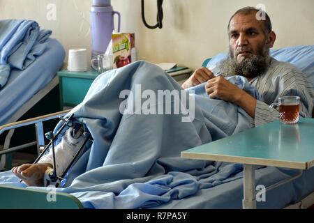 Un patient à l'Hôpital Militaire National de Kaboul reçoit des soins, en dépit d'une récente attaque à l'hôpital. "Je suis fier du personnel médical parce qu'ils se sont battus. J'apprécie ces médecins qui ont couru à l'intérieur risquant leur vie pour aider. Ils ont réussi à évacuer des centaines de patients de la région, y compris les blessés. C'est honorable, a déclaré le Général Abdul Razaq Siawash, commandant de l'Armée nationale afghane medical. Banque D'Images