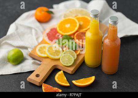 Bouteilles en verre de jus de fruits sur la table d'ardoise Banque D'Images