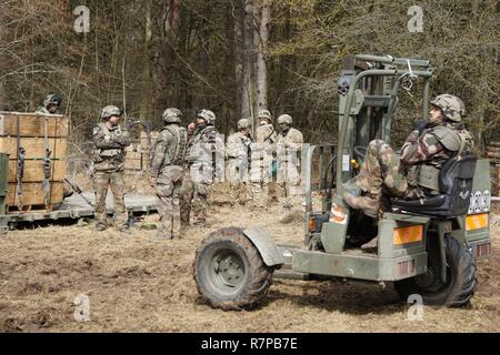 Les soldats de la Compagnie Alpha, 173e Bataillon de soutien de la Brigade, 173e Brigade aéroportée et soldats français du 511e régiment de transport de ravitaillement de munitions de charge sur une télévision de l'armée américaine-rack sur un camion à plateau français lors de l'exercice Allied Esprit VI à l'instruction de l'Armée de la 7e commande Zone d'entraînement, le 20 mars 2017. Exercer l'esprit allié VI comprend environ 2 770 participants de 12 pays membres et partenaires de l'OTAN pour la paix, et des exercices et des tests d'interopérabilité tactique de communications sécurisées à l'intérieur de membres de l'Alliance et des pays partenaires. Banque D'Images