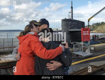 BANGOR, Washington (21 mars 2017) Le Cmdr. Severtson de gènes, commandant de l'équipage d'or de la classe Ohio-balistique sous-marin SNLE USS Nevada (733), embrasse sa famille comme le bateau retourne à base navale Kitsap-Bangor à la suite d'une patrouille de routine de dissuasion stratégique. Le Nevada est l'un des huit sous-marins des missiles balistiques stationnés à la base offrant le plus de chance de survie de la triade de dissuasion stratégique pour les États-Unis. Banque D'Images