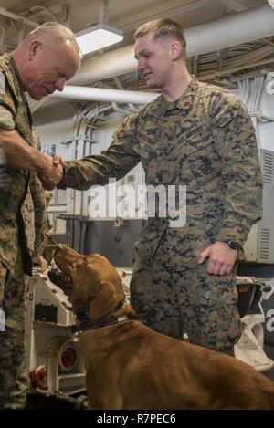 Mer des Philippines (21 mars 2017) Le lieutenant général Lawrence Nicholson, commandant général de l'III Marine Expeditionary Force, accueille Lance Cpl. Alex, Marquissee de Appleton, Wisconsin (Etats-Unis), un chien de travail militaire (MWD) handler affecté à 31e MEU, et son gage MWD, lors d'une visite à bord du navire d'assaut amphibie USS Bonhomme Richard (DG 6). Au cours de sa visite, Nicholson a visité plusieurs centres, s'est entretenu avec Bonhomme Richard marins et soldats de la 31e Marine Expeditionary Unit (MEU) et s'assit pour un dîner avec la commande file. USS Bonhomme Richard, navire amiral du Bonhomme Richard Expeditionary Strike Gr Banque D'Images