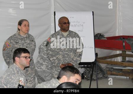 Le colonel Catherine Nadal et commande le Sgt. Le major Juan Waypacheco écouter un membre du 38e Groupe d'appui régional au cours de la finale de l'unité pour l'analyse après action WAREX continue 78-17-01 sur une base commune McGuire Dix Lakehurst, New Jersey. Nadal et Waypacheco diriger la 2e Brigade, Division de la formation de l'Atlantique, 75e Commandement de la formation de l'équipe du contrôleur observateur affecté à la 38e RSG. Banque D'Images