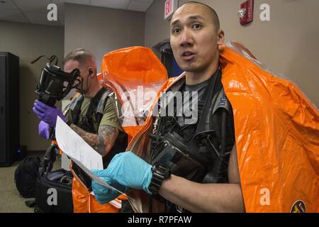 Membre de l'équipe de grève Le s.. Nicky Lam, à droite, avec la Garde nationale du New Jersey's 21e Armes de Destruction-Civil l'équipe de soutien, bref l'entrée d'objectifs de l'équipe lors d'un exercice d'entraînement avec le service d'incendie de Picatinny Arsenal au New Jersey la défense de la patrie (Homeland Security Center à Picatinny Arsenal, N.J., 23 mars 2017. Le 21e ADM-CST est un groupe mixte composé de soldats de la Garde nationale du New Jersey et les aviateurs dont la mission est d'aider les autorités civiles en identifiant les substances chimiques, biologiques, radiologiques et nucléaires dans l'homme ou des catastrophes naturelles. Banque D'Images