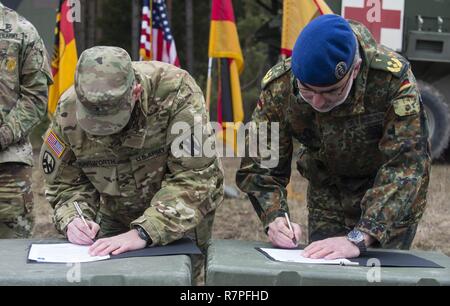 GRAFENWOEHR, Allemagne - Le Général de brigade de l'armée américaine Steven Ainsworth (à gauche), général commandant adjoint du 21e Commandement de soutien du théâtre, et le général Ulrich Baumgartner (droite), général commandant de la Bundeswehr soutien médical opérationnel commande, connectez-vous la toute première note de l'unité de partenariat entre les deux commandes au cours d'une Europe de l'Armée américaine sur le terrain de l'évaluation d'experts médicaux d'un insigne à Grafenwoehr, Allemagne le 24 mars 2017. Environ 215 candidats de l'armée américaine et européenne de dix pays partenaires ont participé à l'évaluation semestrielle dans l'espoir d'atteindre le très convoité U.S. Banque D'Images