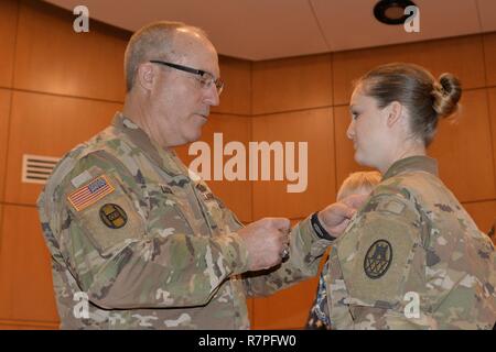 Caroline du soldat de la Garde nationale de la CPS. Semantha Bunce, droite, est honorée avec le soldat de l'Aviateur NCNG et médaille (NCSAM) lors d'une cérémonie à l'administration centrale de la Garde côtière dans la région de Raleigh, 24 mars 2017. "Nous avons besoin d'un moyen de reconnaître ceux qui vont au-delà de l'armée", a déclaré le Major-général Greg Lusk, l'adjudant général de la Caroline du Nord, commandant de l'NCNG, gauche. Bunce sert avec le 105e bataillon du génie de l'administration centrale. En novembre 2015, deux des assaillants armés ont fait irruption dans sa maison. Elle a manoeuvré par les tirs et l'engagea les intrus avec sa propre arme à feu blessant un de ses agresseurs et d'être blessés durin Banque D'Images