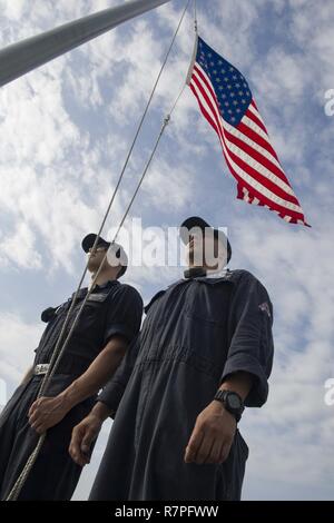 Quais SEMBAWANG, Singapour (23 mars 2017) 1ère classe Mécanicien Luis Espinoza, droite, et dommages 3e classe Controlman Charles Rose, toutes deux affectées à la lutte contre le littoral, le USS Coronado (LCS 4), se préparer à la descente des couleurs du navire avant de commencer. Coronado est un navire de guerre rapide et agile sur mesure pour patrouiller les eaux littorales de la région et travailler à coque coque avec partner marines, fournissant la 7è flotte avec les capacités flexibles dont elle a besoin maintenant et dans l'avenir. Banque D'Images