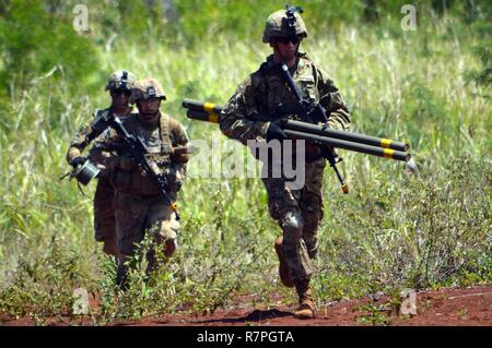 Les ingénieurs de combat affecté à la 29e brigade bataillon du génie, 3e Brigade Combat Team, 25e Division d'infanterie, transporter des torpilles Bangalore comme ils se précipitent à enfreindre un obstacle à Schofield Barracks, Missouri, le 25 mars 2017. Le but de la formation était d'éliminer un obstacle de fil afin que les soldats pouvaient traverser en toute sécurité. Banque D'Images