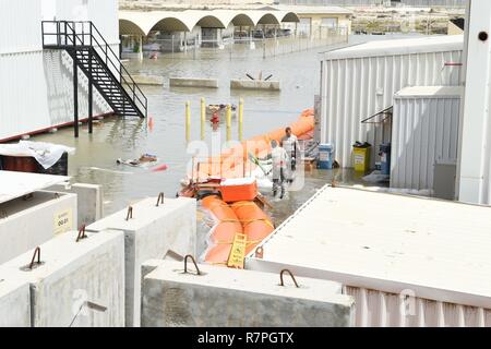 Deux membres de la 380e Escadron de maintenance expéditionnaire déplacer un atelier de fabrication de la pompe de puisard à un meilleur emplacement tout en travaillant à l'eau claire d'une barrière autour de leur immeuble après un violent orage dans un endroit inconnu en Asie du Sud-Ouest, le 24 mars. La barrière faisait partie d'un récent projet mené par le 380e Escadron de génie civil de la Force expéditionnaire du Canada pour réduire les dommages et la mission de l'impact des inondations annuelles prévues. Banque D'Images