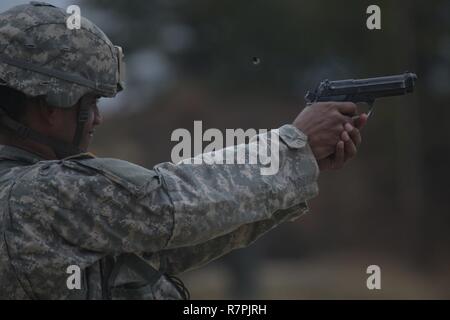 Un soldat de l'Armée américaine à partir de la Garde nationale du New Jersey le feux M9 Beretta durant la partie de tir au pistolet le New Jersey Army National Guard sur la concurrence meilleur guerrier Joint Base McGuire-Dix-Lakehurst, N.J., le 27 mars 2017. Huit soldats et huit sous-officiers sont en concurrence dans l'NJARNG La concurrence meilleur guerrier, Mars 27-29, 2017, qui dispose d'événements temporels, y compris des simulations de combat en zone urbaine, un 12-mile ruck mars, la navigation terrestre, et le test de condition physique de l'armée. Le premier soldat et le sous-officier passe à la concurrence dans la région 1 Concours en avril contre les troupes de la Garde nationale de Banque D'Images