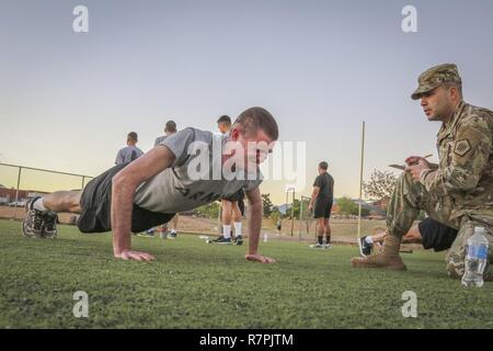 Le sergent de l'armée. Joshua Anderson, spécialiste des technologies de l'information attribuée à la 335e commande de signal (Théâtre) se lance des push-ups comme Sgt. Marwin Gomez, un sous-officier affecté à la formation de la 820e compagnie de transmissions, 98e Bataillon, Signal expéditionnaire 335SC (T) le nombre de répétitions au cours de la condition physique de l'armée à l'Essai de commande 2017 Concours meilleur guerrier à Fort Huachuca, en Arizona, le 27 mars Banque D'Images