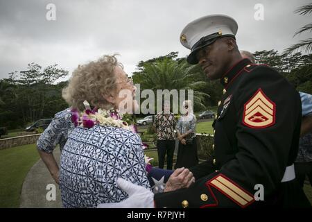 Le s.. Kendrix D. Graham escorts Nancy Hazelbaker après le service commémoratif pour son mari, le Colonel Marine retraité Vincil W. Hazelbaker, à la Hawaiian Memorial Park Cemetery le 24 mars 2017. Après la cérémonie, les hélicoptères de la Marine Aircraft Group 24 a effectué une formation de l'homme manquant, qui est un salut aérien effectué pendant un défilé aérien d'avions à un événement commémoratif, généralement à la mémoire d'un pilote tombé. Hazelbaker était un aviateur de Marine qui a servi dans l'armée depuis 34 ans. Au cours de son service, il a effectué plus de 680 missions de combat et a obtenu la Croix de la Marine pour son extraordinaire h Banque D'Images