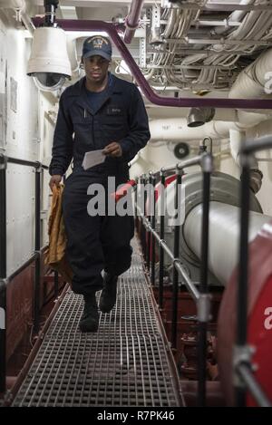 Mer des Philippines (26 mars 2017) 4400 Machiniste Michael Okray pompier, de Dallas, les transits d'une allée d'arbre au cours des contrôles d'huile horaire à bord du navire d'assaut amphibie USS Bonhomme Richard (DG 6). Bonhomme Richard, navire amiral du Bonhomme Richard, avec groupe expéditionnaire lancé 31e Marine Expeditionary Unit, est sur une patrouille de routine, opérant dans la région du Pacifique-Indo-Asia pour améliorer l'état de préparation et la posture de combat de l'avant en tant que force de réaction-prêt pour tout type d'imprévus. Banque D'Images