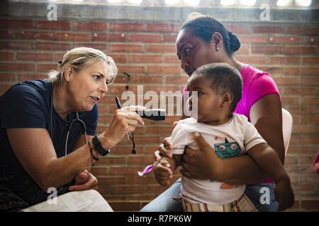 Corvette de la Marine américaine. Ellen Argo, originaire d'Alexandrie, en Virginie, affecté à la Clinique de santé de la Marine Quantico, en Virginie, examine un enfant à la poursuite de promesse 2017 (CP-17) site médical à Mayapo, Colombie, le 22 mars 2017. CP-17 est un U.S. Southern Command-parrainé et U.S. Naval Forces Southern Command/U.S. 4ème flotte-déploiement effectué pour mener des opérations civiles et militaires y compris l'assistance humanitaire, missions de formation, de soins médicaux, dentaires et vétérinaires, de l'assistance dans un effort pour montrer le soutien des États-Unis et de l'engagement de l'Amérique centrale et du Sud. Banque D'Images