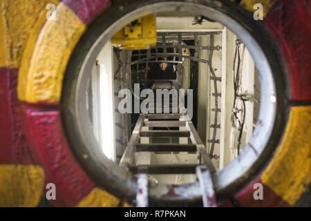 Mer des Philippines (26 mars 2017) 4400 Machiniste Michael Okray pompier, de Dallas, monte sur une échelle verticale après les affaires courantes d'huile horaire chèques dans une allée d'arbre à bord du navire d'assaut amphibie USS Bonhomme Richard (DG 6). Theship et son groupe expéditionnaire, entrepris avec 31e Marine Expeditionary Unit, est sur une patrouille de routine, opérant dans la région du Pacifique-Indo-Asia pour améliorer l'état de préparation et la posture de combat de l'avant en tant que force de réaction-prêt pour tout type d'imprévus. Banque D'Images