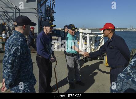 MAYPORT, Floride (24 mars 2017) - a pris sa retraite le Cmdr. Dronzeck Henry (à gauche) et ancien capitaine John Meserve (droite) l'Aviation salue maître de Manœuvre 1re classe (manutention) Steven Phakcnkham tout en visitant le navire d'assaut amphibie USS Iwo Jima (DG 7). Dronzeck a servi comme secrétaire du navire et de gestionnaire du navire USS Iwo Jima (LPH-2) à partir de 1963-1966 alors que Meserve a servi comme directeur général pour l'Iwo Jima à partir de 1984-1987. Banque D'Images