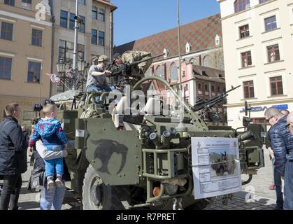 Un soldat britannique de Battle Group Pologne explique le fonctionnement de l'U.K. Jackal Véhicule blindé léger aux visiteurs à l'événement portes ouvertes militaire à Wroclaw, Pologne, le 27 mars 2017. Plus de 3 000 citoyens se sont rendus à la place du marché principal de la ville pour répondre aux États-Unis et Royaume-Uni Pologne Groupe de combat des soldats et leur équipement à l'affichage. Wroclaw a été l'un des arrêts sur la route du groupement tactique à partir de mars, l'Allemagne, à Vilseck Orzysz, Pologne, où il rejoindra l'armée polonaise, la 15ème Brigade Mécanisée et servir de force de dissuasion de l'OTAN dans le cadre du renforcement de la présence de l'avant. Banque D'Images