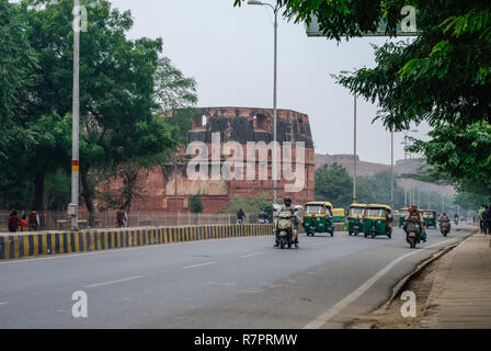 Agra, Inde - 8 janvier 2012 : les taxis et les Tuk Tuk trafic vélos et des murs du Fort Rouge d'Agra à l'arrière-plan, l'Inde. Site du patrimoine mondial de l'UNESCO Banque D'Images