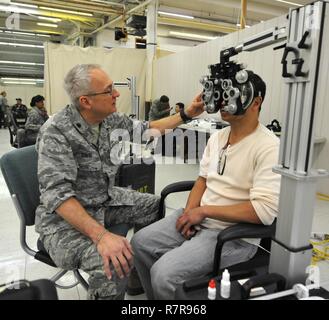 Le lieutenant-colonel Mark Davis avec le 147e Groupe médical ajuste un phoropter manuel afin de trouver le bon verres de prescription pour un patient au cours des soins, de l'Arctique 2017 Le 28 mars 2017, Kodiak, Alaska. Le voyant de la réserve de la Force aérienne Exercice de préparation médicale service donne aux membres la possibilité de s'entraîner sur l'équipement médical déployables en servant tous les citoyens de l'île Kodiak en Alaska. Banque D'Images