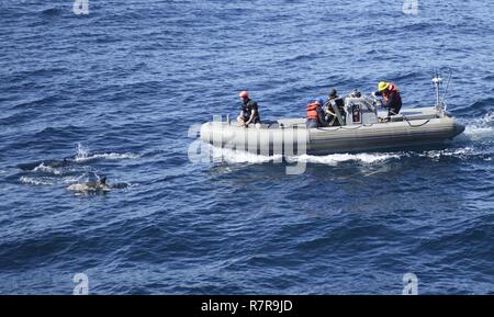 Océan Pacifique (Mars 29, 2017) Les marins de la classe Arleigh Burke destroyer lance-missiles USS Kidd (DDG 100) observer un banc de dauphins pendant une visite, un conseil, vous pouvez, et saisie (VBSS) alors que la formation en cours pour une unité de formation composite (exercice COMPTUEX) avec le groupe aéronaval du Nimitz en préparation pour un prochain déploiement. COMPTUEX teste la préparation aux missions de la grève actifs du groupe grâce à une simulation des scénarios du monde réel et leur capacité à fonctionner comme une unité intégrée. Banque D'Images