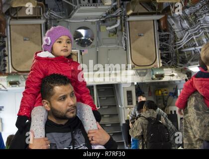 Adelyne Santamaria, situé sur le haut de son père Marco Santamaria par les épaules comme ils regardent les arrimeurs du 512th Airlift Wing démontrer chargement et déchargement d'une C-17 Globemaster III, Dover Air Force Base, Del., 1 avril 2017. 512Th réservistes AW' Les membres de la famille est allé(e) à un mois de l'événement enfant militaire impliquant des tours d'un C-5M Super Galaxy, C-17 Globemaster III, fire station et une démonstration par les chiens de travail. Banque D'Images