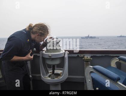 7ème ZONE DES OPÉRATIONS DE LA FLOTTE (20 mars 2017) Ens. Rebecca, Cabrey de Lawton, Oklahoma, est l'agent de manoeuvre sur le bridgewing de classe Arleigh Burke destroyer lance-missiles USS Barry (DDG 52) au cours d'un exercice photo (PHOTOEX) dans le cadre du Foal Eagle 2017. Foal Eagle est un annuel, exercice de formation trilatéral visant à améliorer l'état de préparation des États-Unis et République de Corée forces et de leur capacité à travailler ensemble durant une crise. Banque D'Images