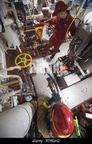 Mer de Chine du Sud (28 mars 2017) Chef d'Controlman Thippanya Anousone dommages, de Milwaukee, Wisconsin, simule un incendie lors d'un forage de contrôle des avaries à bord de la classe Arleigh Burke destroyer lance-missiles USS Michael Murphy (DDG 112). Michael Murphy est en fonction d'un programme de déploiement de l'ouest du Pacifique avec le groupe aéronaval du Carl Vinson dans le cadre de la flotte américaine du Pacifique visant à étendre la commande et des fonctions de contrôle U.S. 3e flotte. Porte-avions de la marine américaine ont patrouillé la grève des groupes Indo-Asia-Pacifique régulièrement et systématiquement pour plus de 70 ans. Banque D'Images