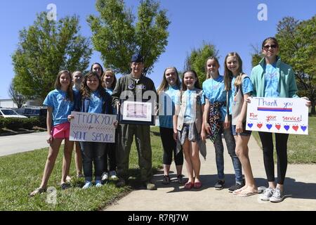 Le colonel de l'US Air Force Troy Gerock (centre), commandant de la 145e Escadre de transport aérien tient à une photo de groupe avec Girl Scouts de pays fournisseurs 20436 au North Carolina Air National Guard Base, Charlotte Douglas International Airport, le 2 avril 2017. Les éclaireuses de Denver, N.C., a fait don de plus de 500 cases étiquetées avec des notes de remerciement personnel ainsi que plusieurs cas de cookies pour envoyer aux membres déployés outre-mer. C'est la quatrième année consécutive les Girl Scouts se sont portés volontaires sur la base, et ils ont présenté Gerock avec une photographie signée pour montrer leur appréciation. Banque D'Images